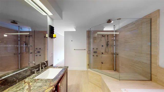 a bathroom with a granite countertop shower sink and mirror