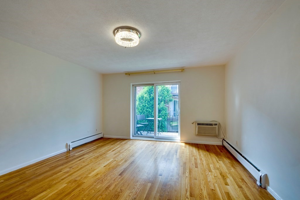 41 Westgate Road, Unit 3 Chestnut Hill, MA 02467 - Photo 6 of 18 an empty room with wooden floor and windows