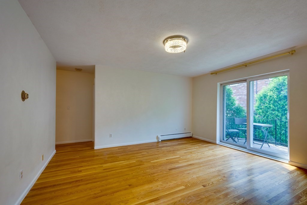 41 Westgate Road, Unit 3 Chestnut Hill, MA 02467 - Photo 7 of 18 a view of an empty room with wooden floor and a window