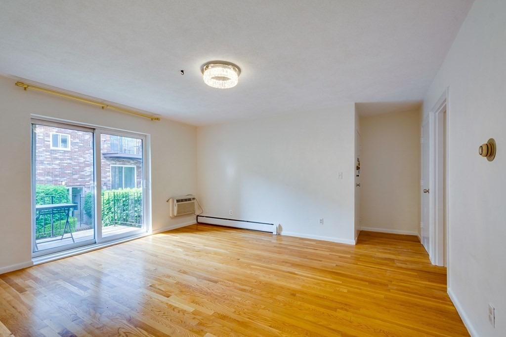 41 Westgate Road, Unit 3 Chestnut Hill, MA 02467 - Photo 8 of 18 a view of an empty room with wooden floor and a window