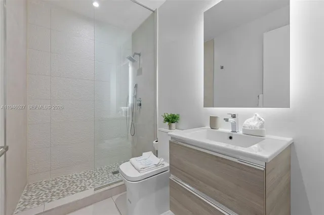 a bathroom with a sink a toilet and shower