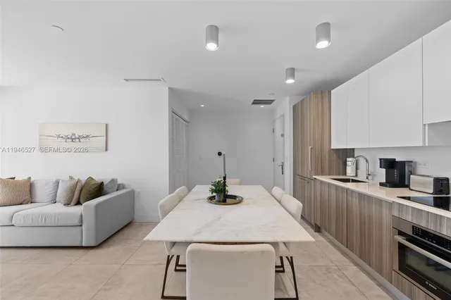 a kitchen with stainless steel appliances kitchen island granite countertop a refrigerator a stove and a sink with wooden floor