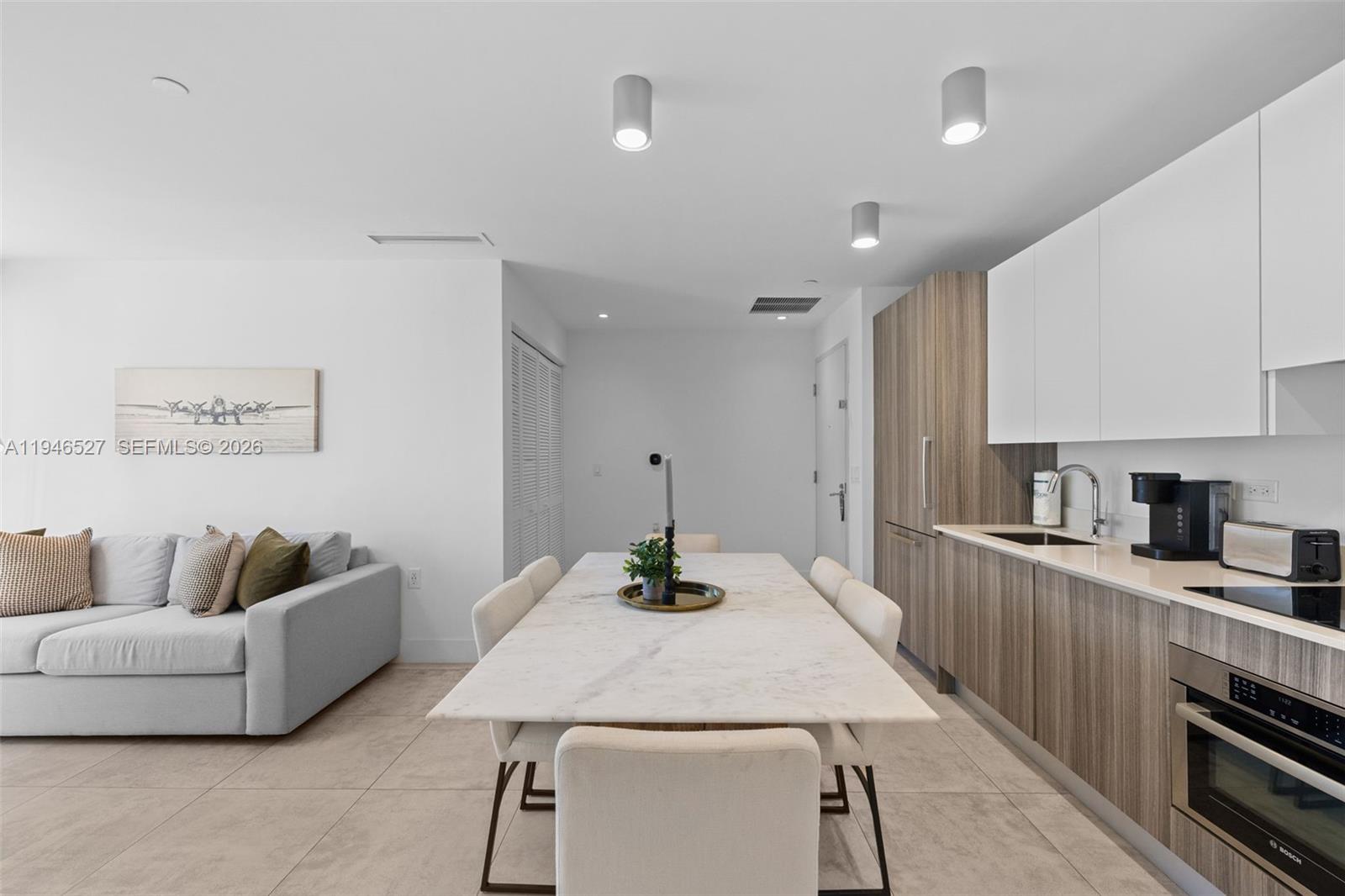 239 Southwest 9th Street, Unit 2304 Miami, FL 33130 - Photo 21 of 35 a kitchen with stainless steel appliances kitchen island granite countertop a refrigerator a stove and a sink with wooden floor