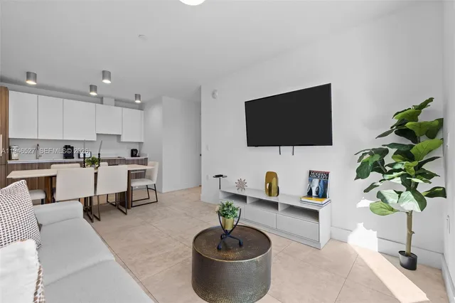 a living room with furniture a potted plant and a flat screen tv