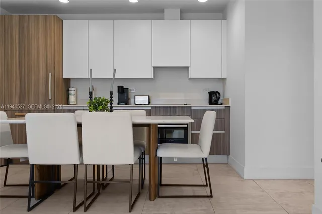 a kitchen with a dining table chairs and cabinets