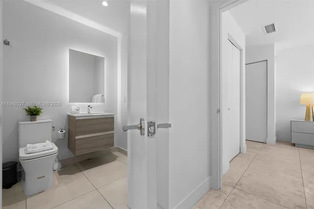 a bathroom with a granite countertop sink a toilet and a mirror