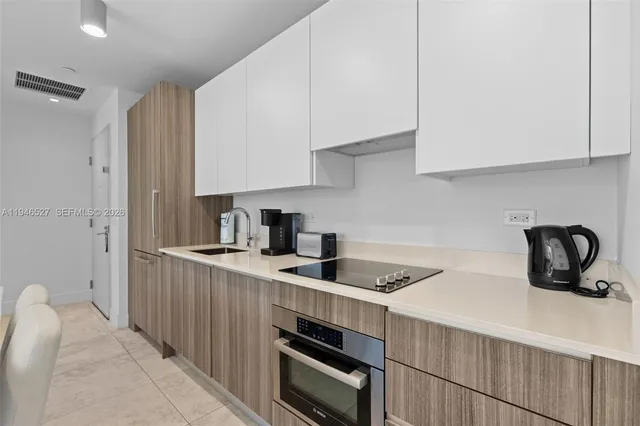 a kitchen with granite countertop a sink stove and cabinets