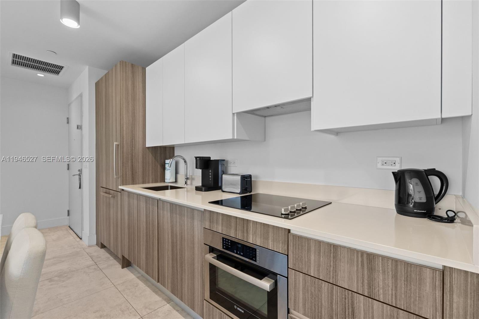 239 Southwest 9th Street, Unit 2304 Miami, FL 33130 - Photo 8 of 35 a kitchen with granite countertop a sink stove and cabinets