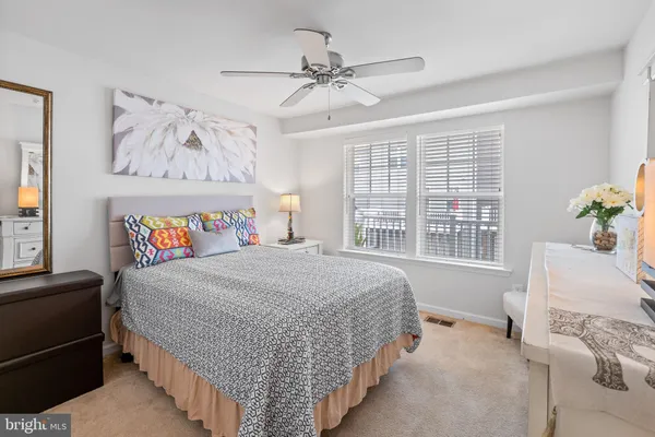 a bedroom with a bed a chandelier and a dresser
