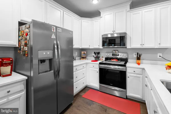 a kitchen with stainless steel appliances a refrigerator stove and white cabinets