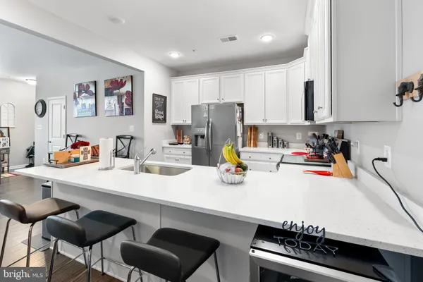 a kitchen with a sink a stove and chairs