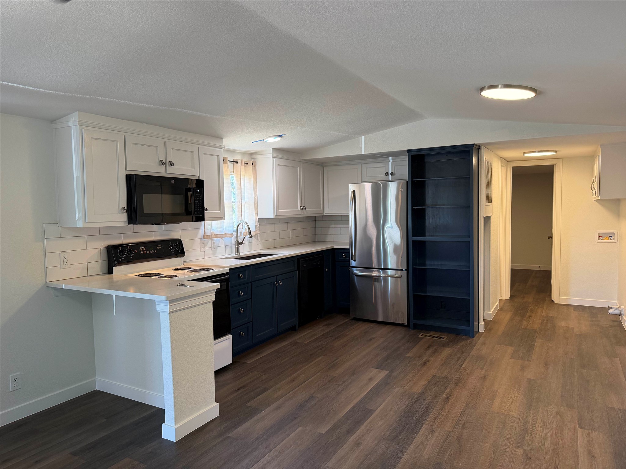 104 Castillo Street Kyle, TX 78640 - Photo 1 of 9 An open kitchen layout showcases classic white and dark cabinetry offset by smooth wood flooring.