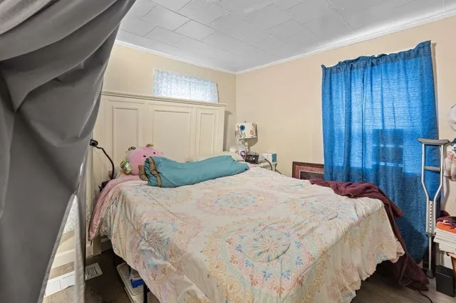 a bedroom with bed and wooden floor
