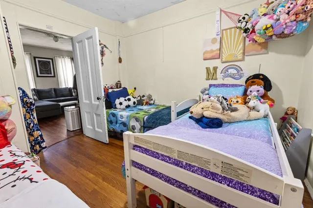 a bedroom with a bed and wooden floor