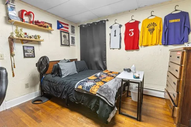 a bedroom with a bed and teddy bear on dresser