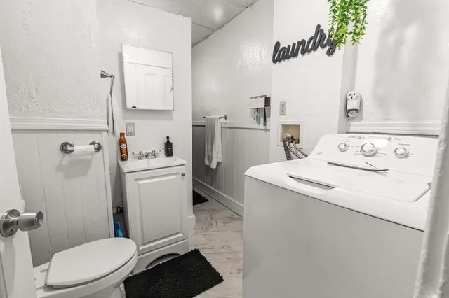 a bathroom with a sink a toilet and a mirror