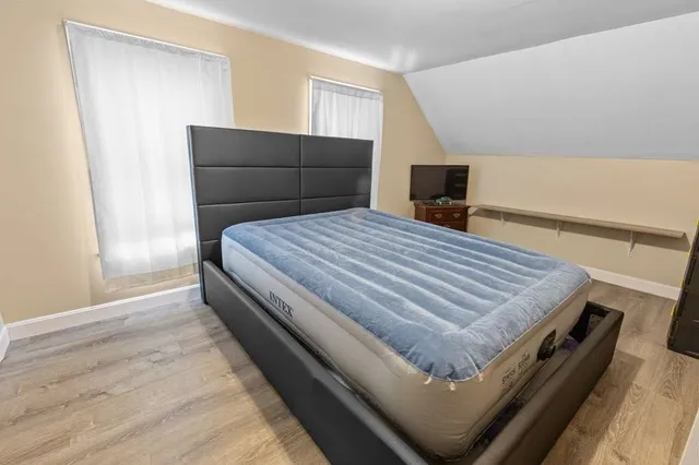 a bedroom with a bed and wooden floor