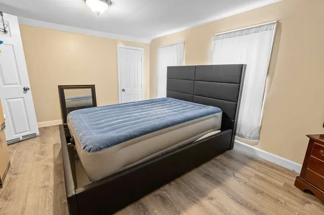 a bedroom with a bed and wooden floor