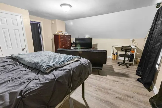 a bedroom with a bed and wooden floor