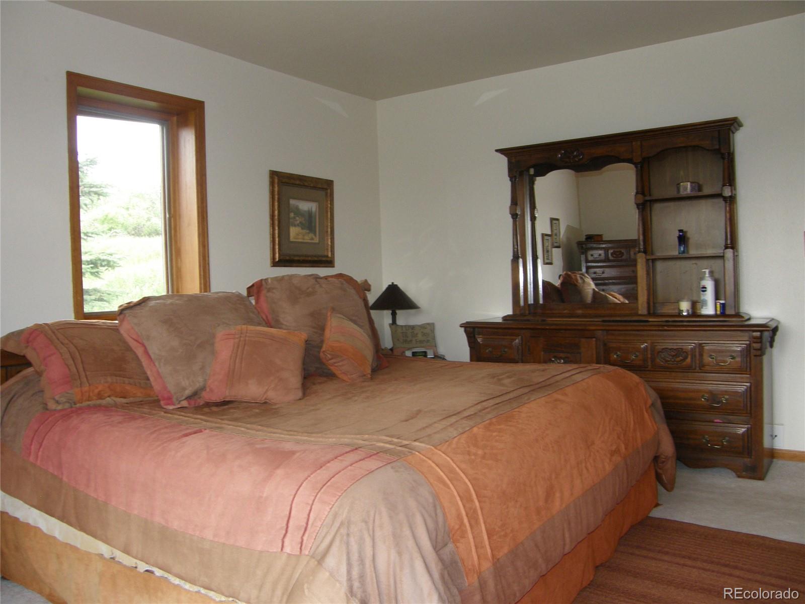 3962 Sugarloaf Road Boulder, CO 80302 - Photo 23 of 34 a bedroom with a large bed and a dresser