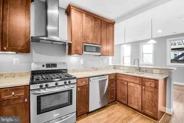 a kitchen with stainless steel appliances granite countertop a stove a sink and a microwave