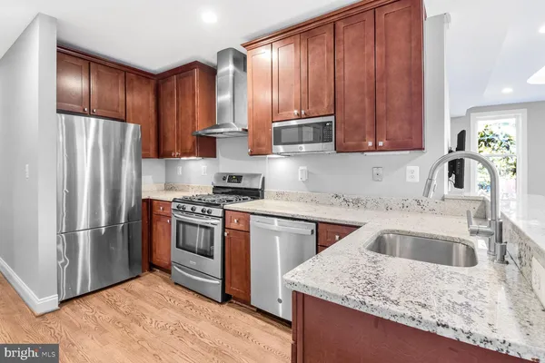 a kitchen with stainless steel appliances granite countertop a refrigerator sink and cabinets