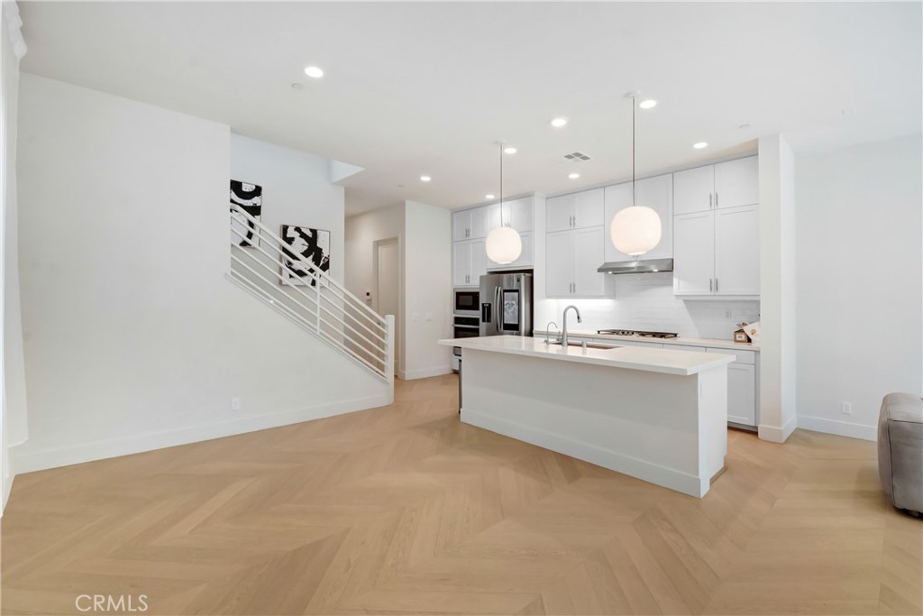 181 Novel Irvine, CA 92618 - Photo 4 of 22 a large white kitchen with kitchen island a sink a stove and a refrigerator