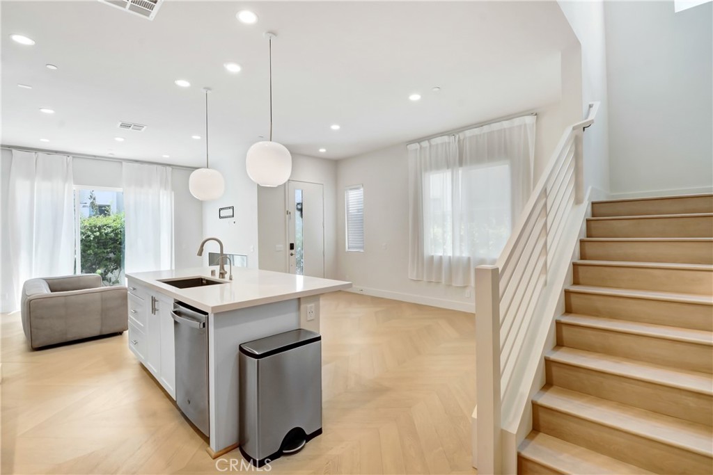 181 Novel Irvine, CA 92618 - Photo 9 of 22 a kitchen with kitchen island a large counter top a sink a stove and a window