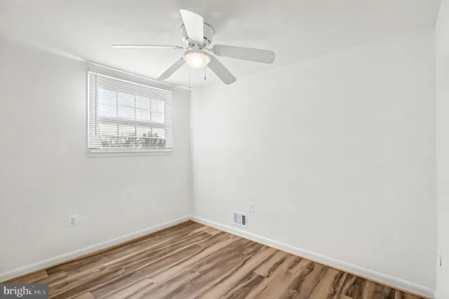 a view of a room with wooden floor and windows