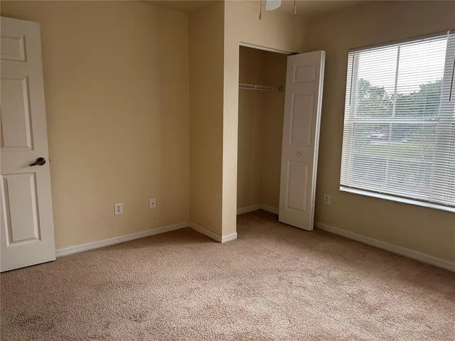 an empty room with windows and closet