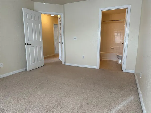 an empty room with closet and a bathroom