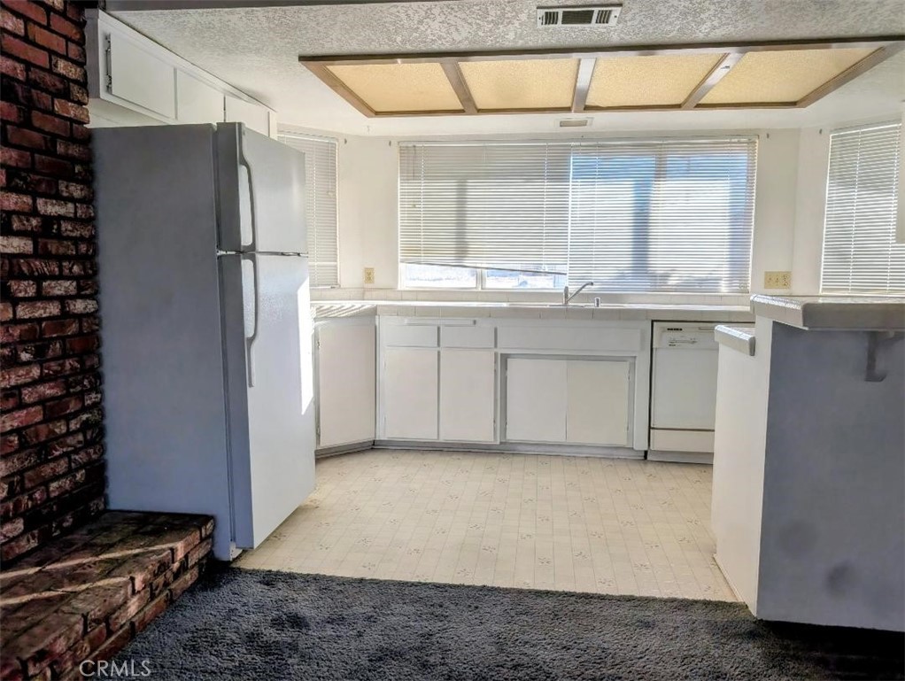 4752 Flying H Road Twentynine Palms, CA 92277 - Photo 22 of 55 a kitchen with a refrigerator and window