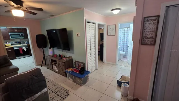 a living room with furniture a flat screen tv and a walk in closet