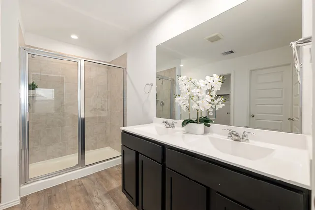 a bathroom with a shower sink and mirror