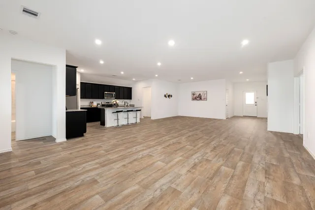 a view of kitchen with kitchen island granite countertop a stove top oven and a sink with granite countertops