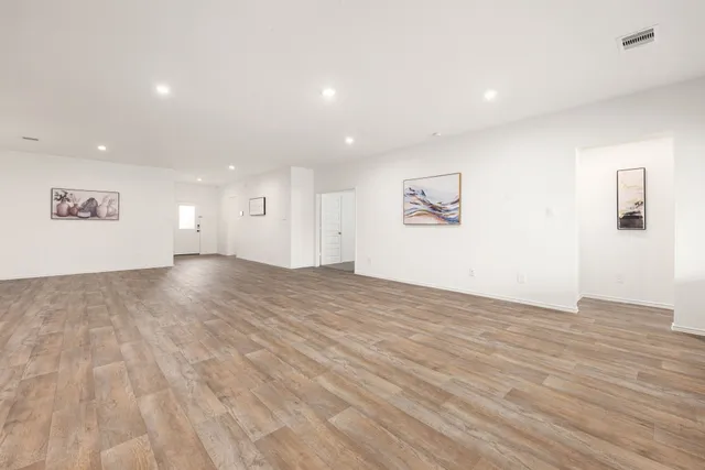 a view of an empty room with wooden floor