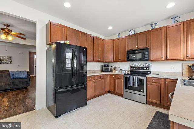 a kitchen with granite countertop a refrigerator stove and microwave