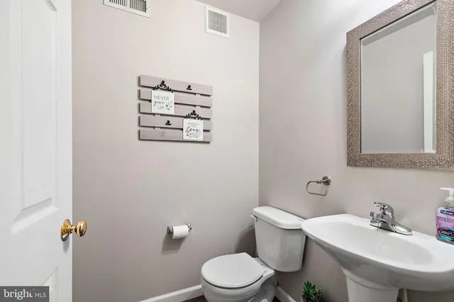 a bathroom with a sink a toilet and mirror