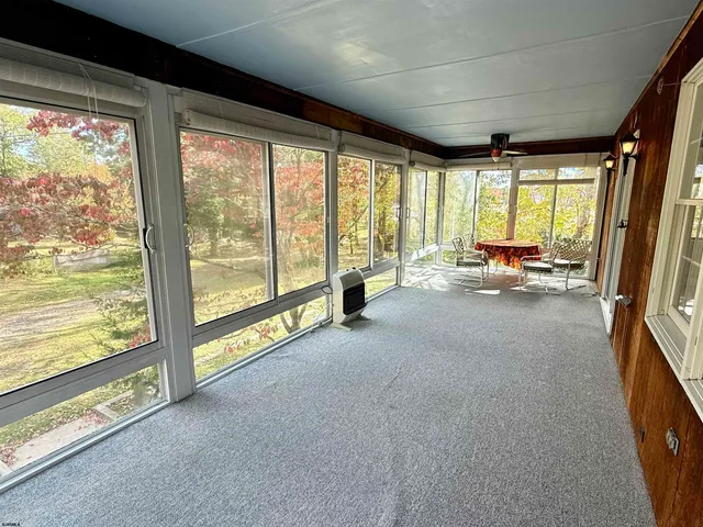 a living room with furniture and floor to ceiling windows