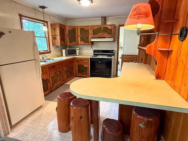 a kitchen with stainless steel appliances granite countertop a refrigerator a stove and a sink