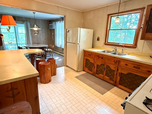 a kitchen with sink a refrigerator and windows
