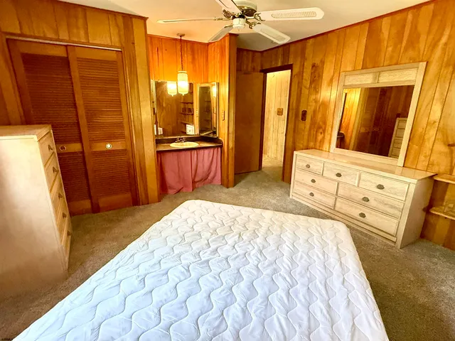 a bedroom with a bed a dresser and a large mirror