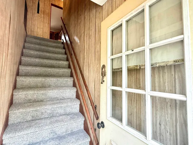 a view of staircase with wooden floor and windows