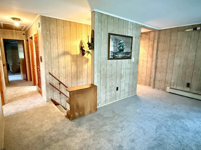 a view of a hallway with wooden floor and cabinet
