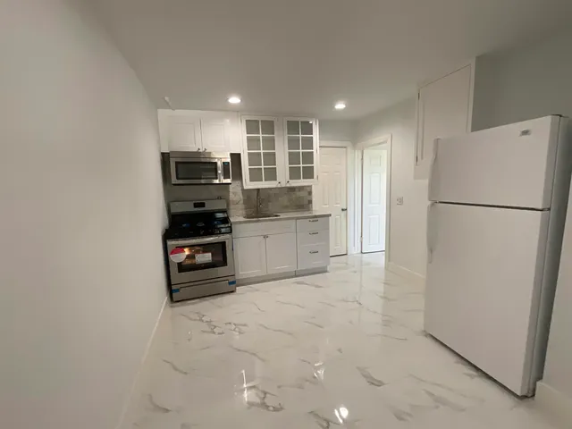 a kitchen with stainless steel appliances a refrigerator and a stove top oven