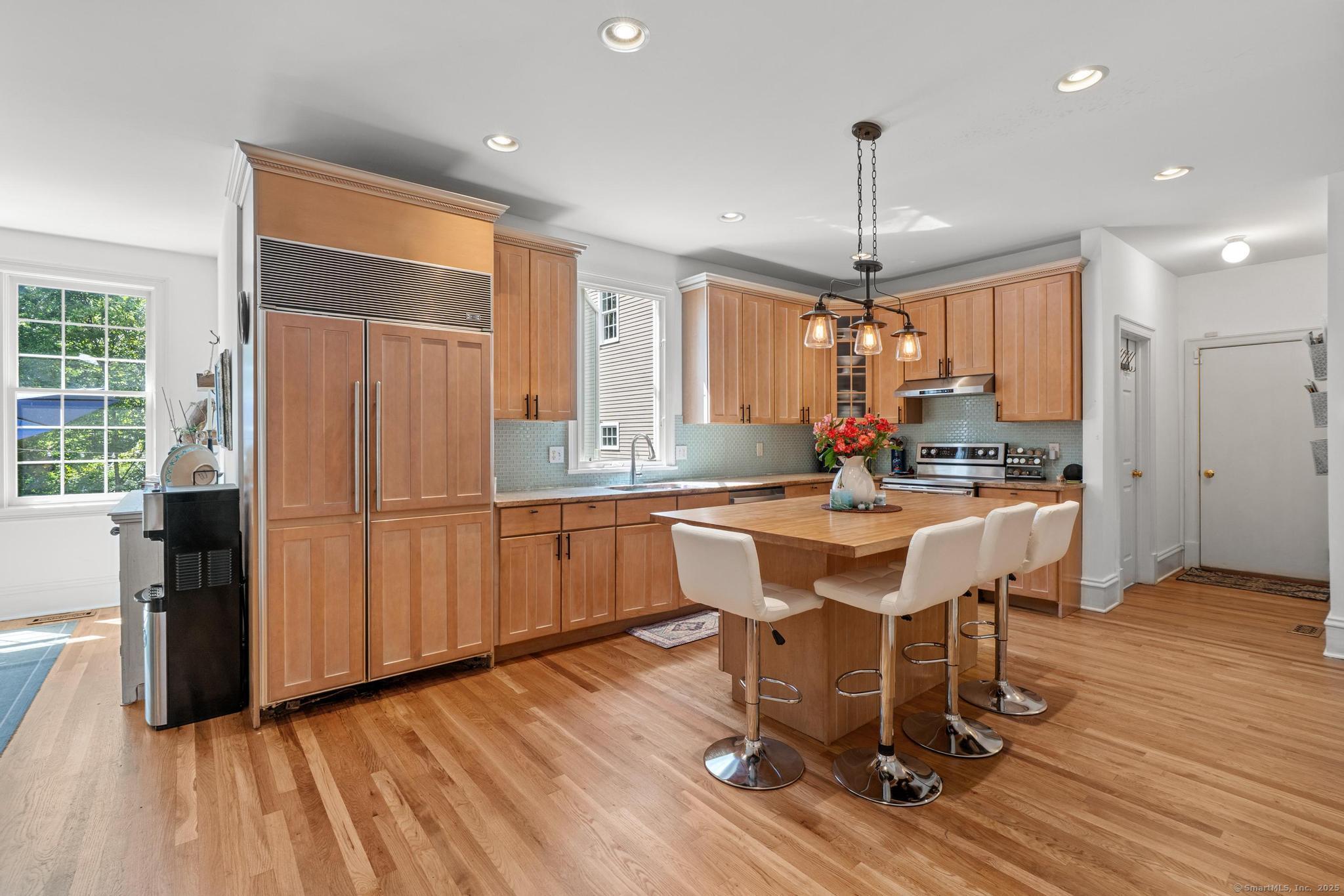13 Orchard Hill Road Norwalk, CT 06851 - Photo 16 of 40 a kitchen with stainless steel appliances granite countertop a refrigerator a sink dishwasher a dining table and chairs with wooden floor