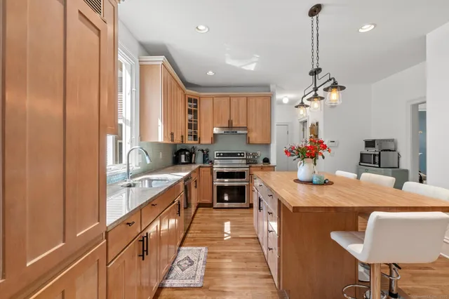 a kitchen with kitchen island granite countertop a sink counter top space appliances and cabinets