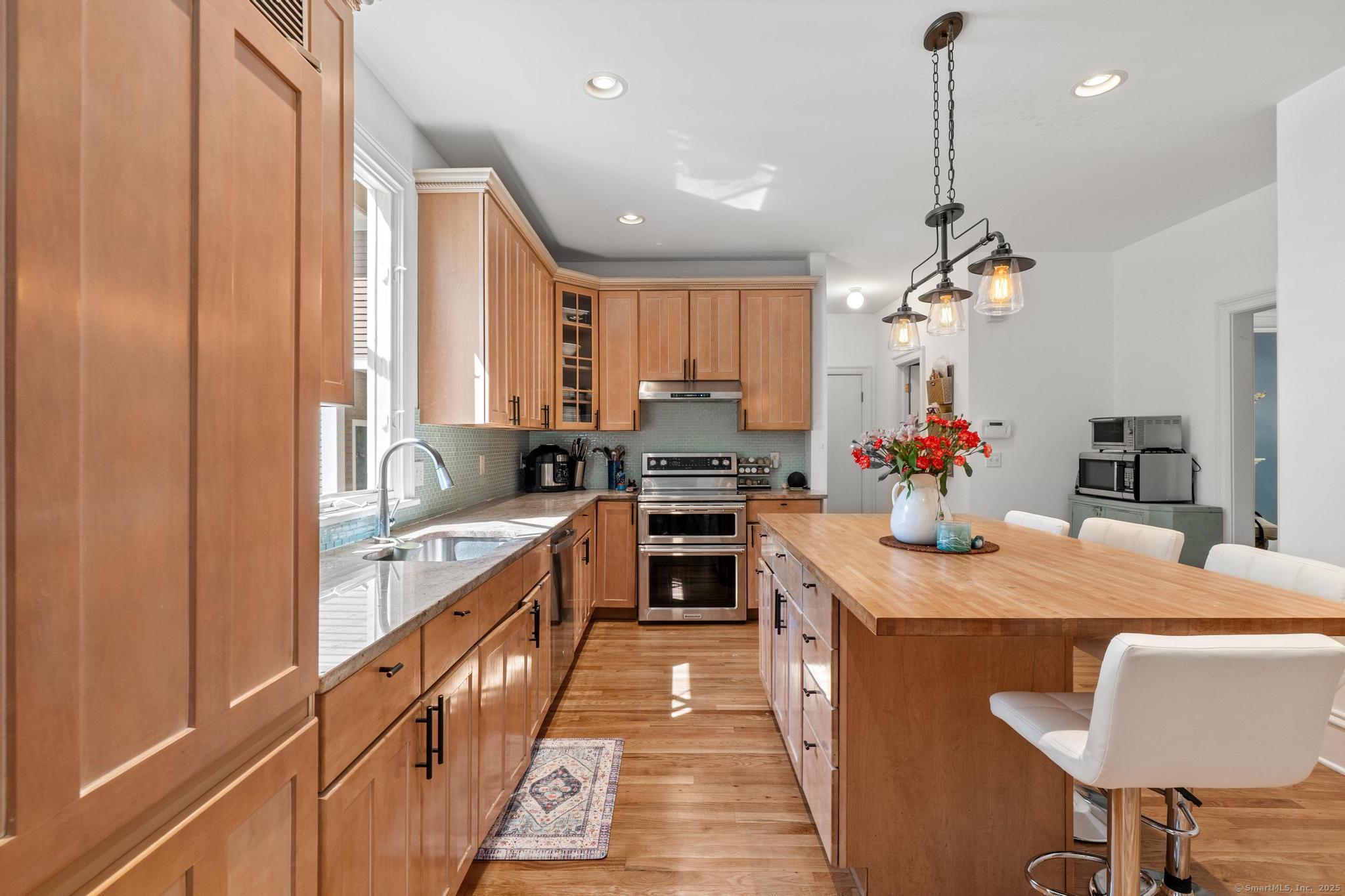 13 Orchard Hill Road Norwalk, CT 06851 - Photo 17 of 40 a kitchen with kitchen island granite countertop a sink counter top space appliances and cabinets