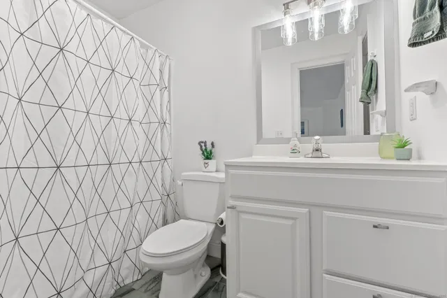 a bathroom with a sink vanity mirror and toilet