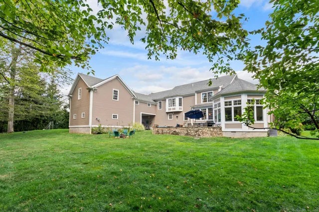 a front view of a house with a garden and trees